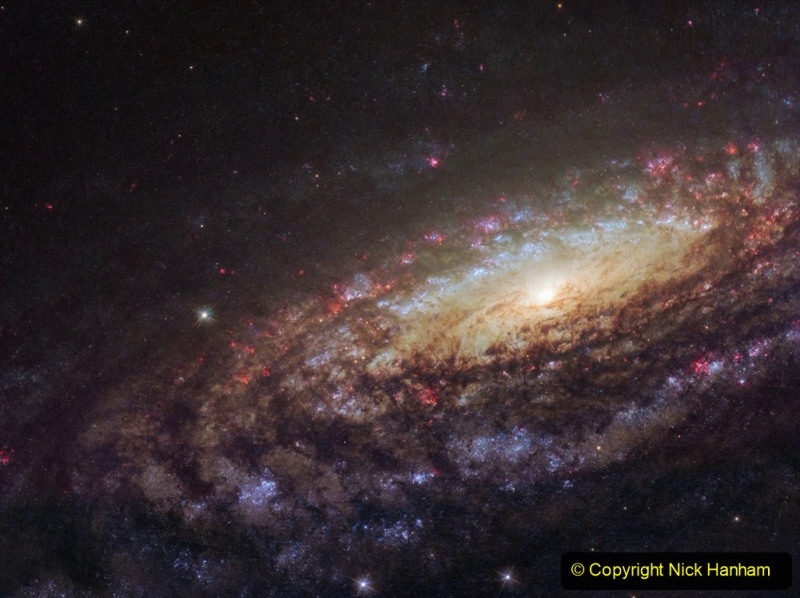 This NASA/ESA Hubble Space Telescope image shows a spiral galaxy known as NGC 7331. First spotted by the prolific galaxy hunter William Herschel in 1784, NGC 7331 is located about 45 million light-years away in the constellation of Pegasus (The Winged Horse). Facing us partially edge-on, the galaxy showcases it’s beautiful arms which swirl like a whirlpool around its bright central region. Astronomers took this image using Hubble’s Wide Field Camera 3 (WFC3), as they were observing an extraordinary exploding star — a supernova — which can still be faintly seen as a tiny red dot near the galaxy’s central yellow core. Named SN2014C, it rapidly evolved from a supernova containing very little Hydrogen to one that is Hydrogen-rich — in just one year. This rarely observed metamorphosis was luminous at high energies and provides unique insight into the poorly understood final phases of massive stars. NGC 7331 is similar in size, shape, and mass to the Milky Way. It also has a comparable star formation rate, hosts a similar number of stars, has a central supermassive black hole and comparable spiral arms. The primary difference between our galaxies is that NGC 7331 is an unbarred spiral galaxy — it lacks a “bar” of stars, gas and dust cutting through its nucleus, as we see in the Milky Way. Its central bulge also displays a quirky and unusual rotation pattern, spinning in the opposite direction to the galactic disc itself. By studying similar galaxies we hold a scientific mirror up to our own, allowing us to build a better understanding of our galactic environment which we cannot always observe, and of galactic behaviour and evolution as a whole.