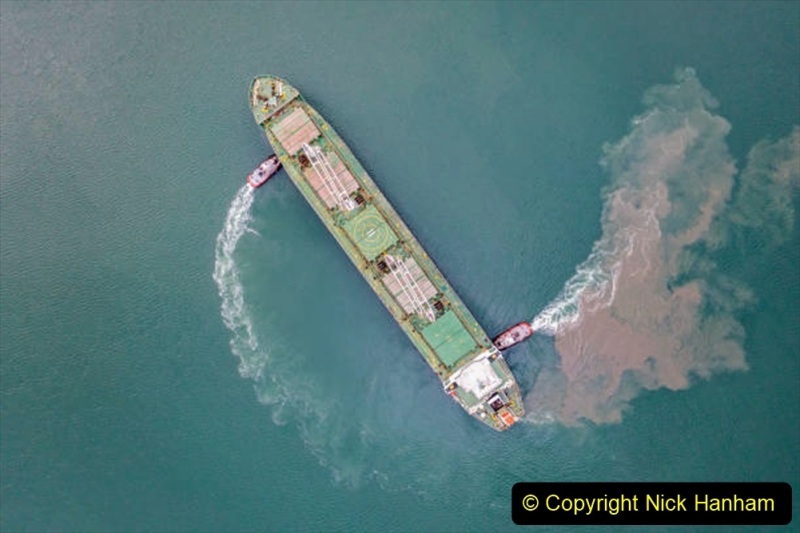 Harbour tugboat guides a cargo ship into the harbour of Samsun - Turkey - Taken with DJI Mavic 2 Pro, You can see more shipping concept images in my portfolio. Aerial drone view of a container ship nearing port with the assistance of a tugboat